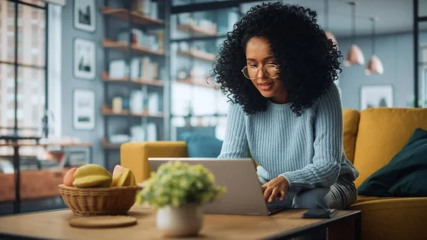 Evdeki Evdeki Gece ve Tablet Bilgisayarı 'nda, Rahat Karanlık Oturma Odasında, Koltukta Oturan Güzel Otantik Latin Kadın. İnterneti geziyor, Stylus Kalem 'le yazı ve çizim yapıyor..