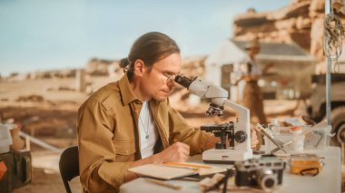 Arkeolojik Kazı Alanı: Yerel Kültür Araştırması Yapan Erkek Arkeolog, Antik Uygarlık Tarihi Eserleri Buldu, Fosil Kazı Alanında Kaldı, Mikroskop Altında İnceledi