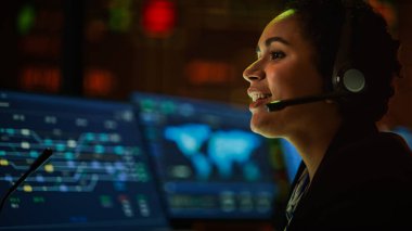 Profesyonel IT Teknik Destek Uzmanı ve Yazılım Geliştiricisi Dijital Ekranlarla Bilgisayar Kontrol Odasında çalışıyor. Çalışan Mikrofonlu Kulaklık Kullan ve Konuşurken Çağrı Yap.