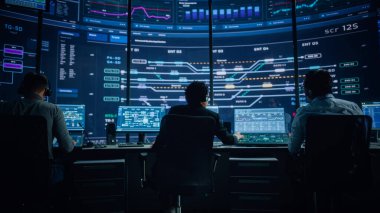 Profesyonel IT Teknik Destek Uzmanı ve Yazılım Geliştiricisi Dijital Ekranlarla Bilgisayar Kontrol Odasında çalışıyor. Çalışan Mikrofonlu Kulaklık Kullan ve Konuşurken Çağrı Yap.