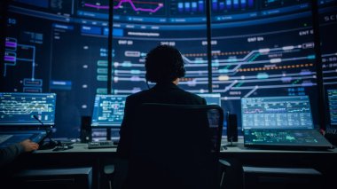 Profesyonel IT Teknik Destek Uzmanı ve Yazılım Geliştiricisi Dijital Ekranlarla Bilgisayar Kontrol Odasında çalışıyor. Çalışan Mikrofonlu Kulaklık Kullan ve Konuşurken Çağrı Yap.