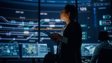 Profesyonel IT Teknik Destek Uzmanı ve Yazılım Geliştiricisi Dijital Ekranlarla Bilgisayar Kontrol Odasında çalışıyor. Çalışan Mikrofonlu Kulaklık Kullan ve Konuşurken Çağrı Yap.