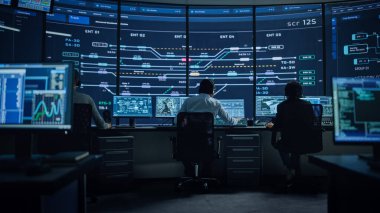 Profesyonel IT Teknik Destek Uzmanı ve Yazılım Geliştiricisi Dijital Ekranlarla Bilgisayar Kontrol Odasında çalışıyor. Çalışan Mikrofonlu Kulaklık Kullan ve Konuşurken Çağrı Yap.