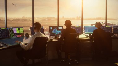 Çeşitli Hava Trafik Kontrol Ekibi Sunset 'teki Modern Havaalanı Kulesi' nde çalışıyor. Ofis Odası, Kontrol Edenler için Uçak Uçuş Radar Verisi, Navigasyon Ekranlarıyla Masaüstü Bilgisayarı ile Doludur.