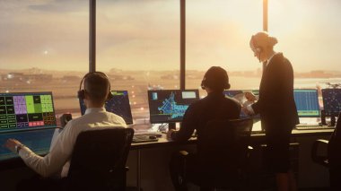 Çeşitli Hava Trafik Kontrol Ekibi Sunset 'teki Modern Havaalanı Kulesi' nde çalışıyor. Ofis Odası, Kontrol Edenler için Uçak Uçuş Radar Verisi, Navigasyon Ekranlarıyla Masaüstü Bilgisayarı ile Doludur.