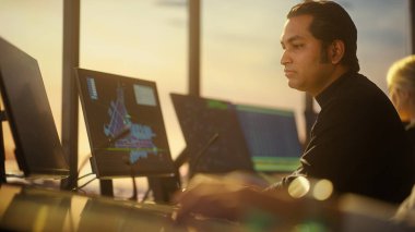 Havalimanı Kulesi 'ndeki Erkek Hava Trafik Kontrolörü ve Kulaklık Konuşması. Ofis Masaüstü Bilgisayarı ile dolu Navigasyon Ekranları, Uçak Uçuş Radar Verisi.