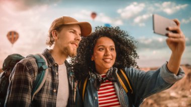Rocky Canyon Vadisi 'nden Sosyal Medya' ya Selfie Mesajı yollayan ya da kaydeden genç turist çifti. Sırt çantalı arkadaşlar macerada. Mountain Ulusal Parkı 'nda Sıcak Hava Balonları.