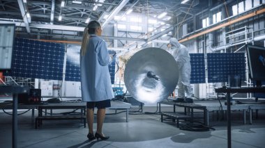 Kadın Mühendis, Uydu İnşaatı 'nda çalışırken Tablet Bilgisayar kullanıyor. Uzay Ajansı İmalat Tesisi: Bilim adamları Uzay Keşif ve Gözlem Görevi İçin Uzay Aracı İnşa Ediyor, Birleştiriyor