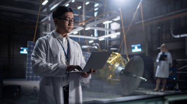 Yapay uydu inşaatında çalışan endüstriyel mühendis. Uzay Ajansı: Uzay Keşfi ve Veri İletişimi için Uzay Aracı Geliştirmek İçin Bilgisayar Kullanan Asyalı Bilim Adamı.