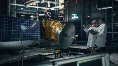 Uydu inşaatında çalışan mühendis ve teknisyen. Uzay Ajansı: Uzay Keşfi için Uzay Aracı geliştirmek için Teknolojik Ekip ve Tablet Bilgisayar kullanan çeşitli bilim adamları.