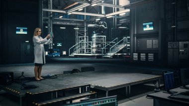 Kadın Mühendis, Fabrika 'daki bir Endüstriyel Tesis' te çalışırken Tablet Bilgisayar kullanıyor. Bilim adamı Artırılmış Gerçeklik Yazılımı kullanıyor. VFX için Boş Alan Şablonu.