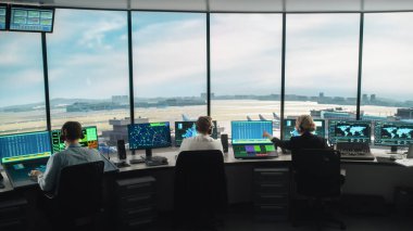 Modern bir havaalanı kulesinde çalışan çeşitli hava trafik kontrol ekibi. Ofis Odası Masaüstü Bilgisayarı ile dolu Navigasyon Ekranları, Uçak Ayrılışı ve Denetleyiciler için Gelen Veri.