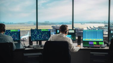 Modern bir havaalanı kulesinde çalışan çeşitli hava trafik kontrol ekibi. Ofis Odası Masaüstü Bilgisayarı ile dolu Navigasyon Ekranları, Uçak Ayrılışı ve Denetleyiciler için Gelen Veri.