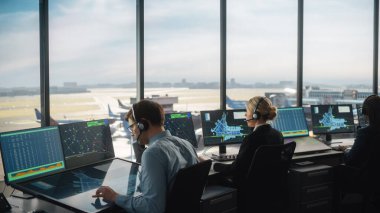 Modern bir havaalanı kulesinde çalışan çeşitli hava trafik kontrol ekibi. Ofis Odası Masaüstü Bilgisayarı ile dolu Navigasyon Ekranları, Uçak Ayrılışı ve Denetleyiciler için Gelen Veri.