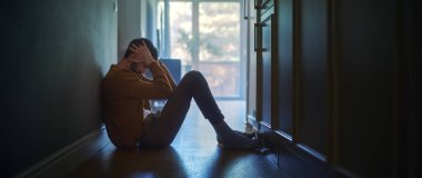 Evinin koridorunda yerde oturan üzgün orta yaşlı bir adam elleriyle yüzünü kapatıyordu. Depresyon, Hastalık, Trajedi, Ailede Ölüm Atmosferi. Dramatik Kötü Haber Anı