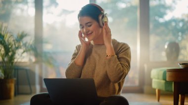 Evde dizüstü bilgisayar kullanan, uzaktan kumandalı çalışan, kulaklıkla müzik dinleyen genç bir kadın. Zeminde oturan güzel, güler yüzlü kız müzikten zevk alıyor, biraz dans ediyor, beyin fırtınası yaratıcı proje.