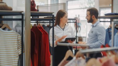 Giyim Mağazası: İş kadını Tablet Bilgisayar kullanıyor, Görsel Ticaret Uzmanıyla konuşuyor, Moda Koleksiyonu Yaratmak İçin İşbirliği yapıyor. İş Sahibinin Moda Dükkanı: Satış Müdürü Tasarımcıyla Konuşuyor