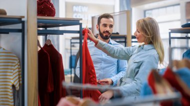 Giyim Mağazasından Güzel Kadın Müşteri Alışverişi, Perakende Satış Ortaklığı Danışmanlığa Yardım Ediyor. Moda Mağazasında Çeşitli İnsanlar, Şık Kıyafetler Seçmek, Sürdürülebilir Tasarımlı Renkli Markalar