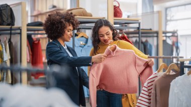 Genç Bayan Müşteri Alışverişi Giyim Mağazasından, Perakende Satış Ortaklığı Danışmanlığa Yardım Ediyor. Moda Mağazasında Çeşitli İnsanlar, Şık Kıyafetler Seçmek, Sürdürülebilir Tasarımlı Renkli Markalar