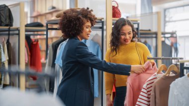 Genç Bayan Müşteri Alışverişi Giyim Mağazasından, Perakende Satış Ortaklığı Danışmanlığa Yardım Ediyor. Moda Mağazasında Çeşitli İnsanlar, Şık Kıyafetler Seçmek, Sürdürülebilir Tasarımlı Renkli Markalar