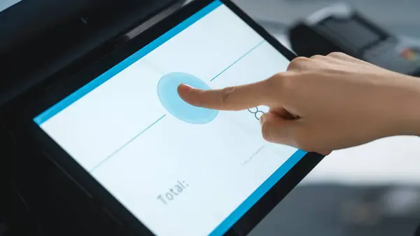Close Up Shot of a Person Touching an Electronic Fingerprint Recognition Feature on a Digital Screen in Order to Make a Purchase in a Clothing Store. Customer Buying Items in Shop with Digital ID.