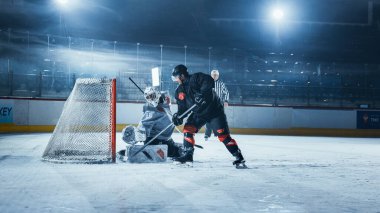 Ice Hockey Rink Arena: Goalie is Ready to Defend Score against Forward Player who Shoots Puck with Stick. Forwarder against Goaltender One on One. Tension Moment in Sport Full of Emotions. clipart