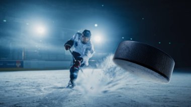 Ice Hockey Rink Arena: Professional Player Shooting the Puck with Hockey Stick. Focus on 3D Flying Puck with Blur Motion Effect. Dramatic Wide Shot, Cinematic Lighting. clipart