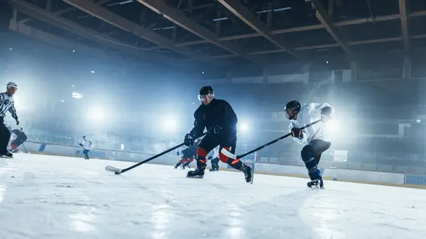 Ice Hockey Rink Arena: Professional Forward Player Attacks, Shows Expert Stickhandling, Dribbles, Handling Puck with Hockey Stick Beautifully, Defense Unable to Intercept. Dutch Angle View.