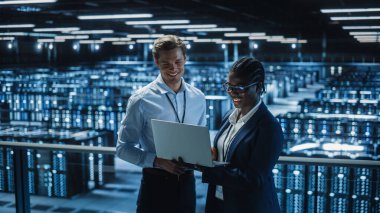 Veri Merkezi Kadın Sistem Yöneticisi ve Erkek Bilişim Uzmanı konuşması, Laptop kullanın. Bilgi Teknolojisi Mühendisleri Cloud Computing Server Farm 'da Siber Güvenliğin Korunması üzerine çalışıyor.