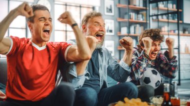Home Three Joyful Soccer hayranları TV 'de bir kanepede oturmuş, Spor Takımı Şampiyonluğu' nu kazandığında zaferi kutluyorlar. En Sevilen Futbol Kulübü Oyunu 'nda Arkadaşlar Grubu Tezahürat Eder.