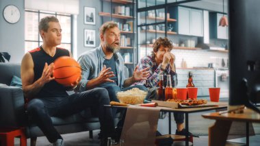 Home Three Joyful Basketball Fans TV 'de bir kanepede oturup maç seyrediyor, Gergin Anlık Befofre Son Atış ve Takım Şampiyonası Zaferi. Arkadaşlar Grubu Favori Kulüp Oyunu Oynadığında Neşelenir.
