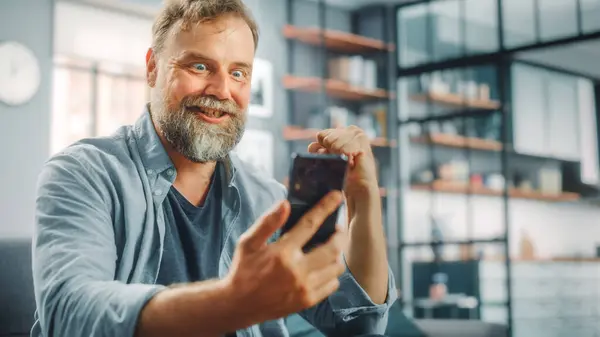 Charismatický Vousatý Muž Sedí Gauči Hodinky Hry Televizi Používá Smartphone — Stock fotografie