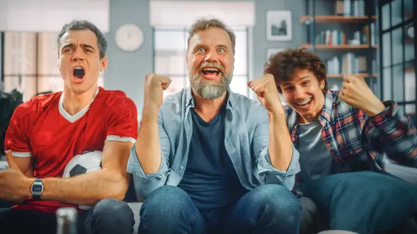 Kotona Kolme Joyful Soccer Fans Istuu Sohva Katsella Peliä Televisiossa — kuvapankkivalokuva
