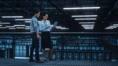 Veri Merkezi Kadın Sistem Yöneticisi ve Erkek Bilişim Uzmanı Konuşması, Laptop Bilgisayarı Kullan. Bilgi Teknolojisi Mühendisleri Bulut Bilgisayar Çiftliğinde Siber Güvenlik Ağ Koruması üzerine çalışıyor.