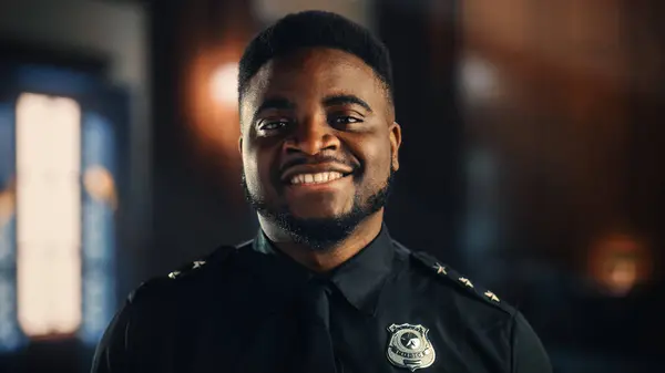 镜头前穿着统一制服微笑的快乐英俊的黑人警察的真实形象 成功的非裔美国人执法机构 审判室警卫在工作 — 图库照片