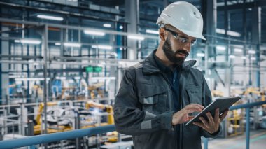 Car Factory Engineer in Work Uniform Using Tablet Computer. Automotive Industrial Manufacturing Facility Working on Vehicle Production with Robotic Arms Technology. Automated Assembly Plant. clipart