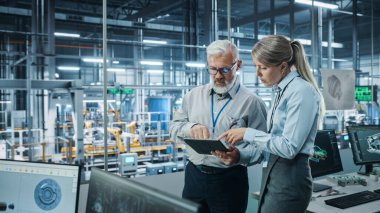Otomobil Fabrikası: Kadın Proje Yöneticisi Erkek Otomotiv Mühendisi, Tablet Bilgisayar Planlama Stratejisi ile Görüştü. Otomatik Robot Silahları Toplama Hattı Üretim Üretim Elektrikli Araçlar