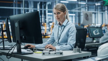 Otomobil Fabrikası: Masaüstü Bilgisayarı üzerinde çalışan kendinden emin kadın mühendisin portresi. Otomatik Robot Silahlanma Hattı Üretiminde Profesyonel Teknisyen Yüksek Teknolojik Elektrikli Araçlar