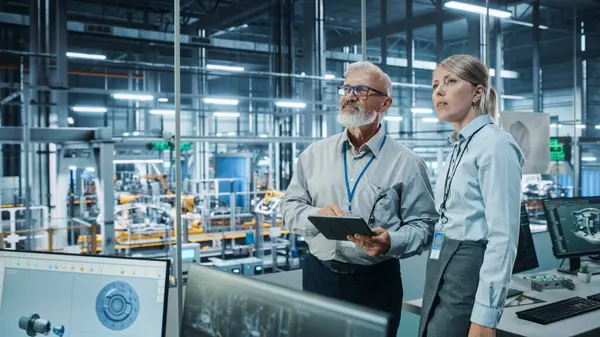 Otomobil Fabrikası: Kadın Proje Yöneticisi Erkek Otomotiv Mühendisi, Tablet Bilgisayar Planlama Stratejisi ile Görüştü. Otomatik Robot Silahları Toplama Hattı Üretim Üretim Elektrikli Araçlar