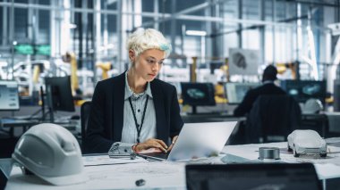 Otomobil montaj tesisinde dizüstü bilgisayarda çalışan ve yöneten genç güzel mühendis. Teknolojik Geliştirme Tesisinde Araç Parçaları üzerine çalışan Endüstriyel Uzman.