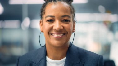 Beyaz Ceket Giyen Güzel Mutlu Genç Bir Kadın 'ın Portresi, Kameraya Bakıyor, Poz Veriyor ve Çekici Gülümsüyor. Kahverengi gözlü başarılı esmer kadın çeşitli şirketlerde çalışıyor..