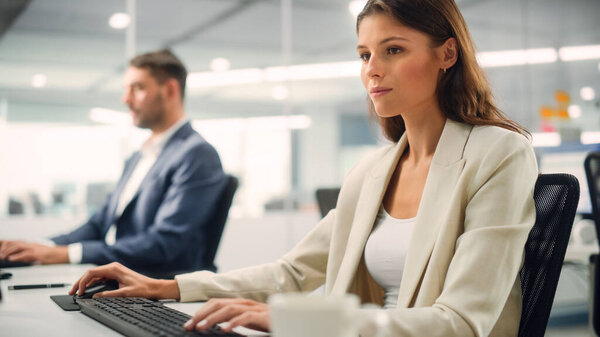 Portrait of a Beautiful Happy Young Female Wearing White Jacket, Looking at Camera, Posing and Charmingly Smiling. Successful Brunette Woman with Brown Eyes Working in Diverse Company Office.