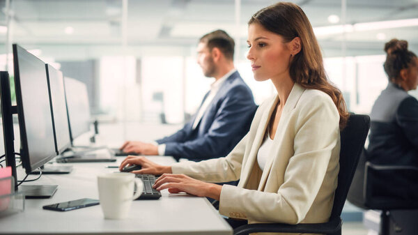 Portrait of a Beautiful Happy Young Female Wearing White Jacket, Looking at Camera, Posing and Charmingly Smiling. Successful Brunette Woman with Brown Eyes Working in Diverse Company Office.