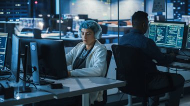 Geceleyin Çeşitli Ofisler: Bilgisayarlar, Ekranlar Kodlama Dili Kullanıcı Arayüzü Üzerinde Çalışan Çok Etnik Genç Programcılar Ekibi. Yazılım Mühendisleri Yenilikçi E-Ticaret Uygulaması Oluşturdu.