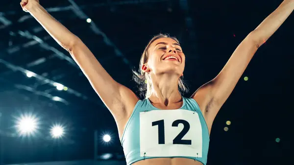 体育锦标赛举臂欢庆世界纪录的专业女运动员在体育场的画像 灵感是成功故事的关键 — 图库照片