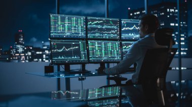 Finansal Analizci Multi-Monitor Workstation ve Real-time Stocks, Commodities ve Foreign Exchange Charts ile bir bilgisayar üzerinde çalışıyor. Yatırım Bankası Şehir Ofisinde Gece İşadamı Çalışıyor.