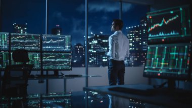 Financial Analyst Using Laptop Computer, Standing Next to Multi-Monitor Workstation with Real-Time Stocks, Commodities and Exchange Market Charts. Businessman Working in Broker Agency Office. clipart