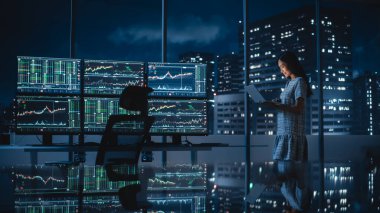 Finansal Analizci Laptop Bilgisayar Kullanıyor, Gerçek zamanlı borsa ve borsa grafikleriyle Çoklu Monitör Çalışma İstasyonunun yanında duruyor. Yatırım Bankası Şehir Ofisi 'nde çalışan iş kadını.