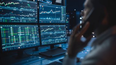 Finansal Gün Tüccarı, Multi-Monitor Workstation ile bir bilgisayar üzerinde çalışıyor. Gerçek zamanlı borsa çizelgeleri ve bir müşteriyle telefonda konuşuyor..