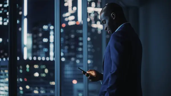 Night Office Successful Black Businessman Wearing Suit Standing Using Smartphone – stockfoto